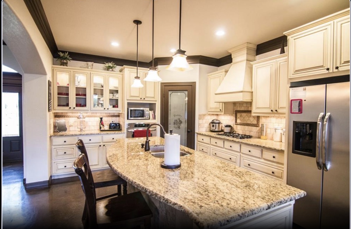 Custom kitchen with granite island and cream cabinets